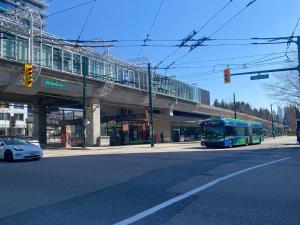 um autocarro a descer uma rua debaixo de um viaduto em Cozy 2 beds Spacious rooms,Close to transit em Vancouver