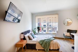 een slaapkamer met een bed en een raam bij Leonardo Studio Apartments In City Center in Rīga