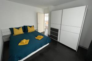 1 dormitorio con 1 cama con almohadas amarillas en Appartement Tourbillon centre-ville en Sion