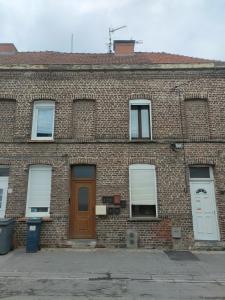 ceglany budynek z brązowymi drzwiami i oknami w obiekcie Studio "Sous les toits", Proche Hyper Centre et Commerces ! w mieście Valenciennes
