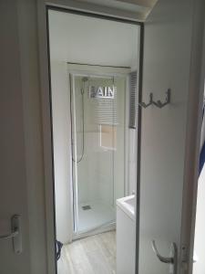 prysznic w łazience ze szklanymi drzwiami w obiekcie Mobilhome 6 pers avec Clim w mieście Saint-Georges-de-Didonne