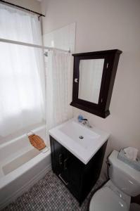 a bathroom with a sink and a toilet and a mirror at Heritage Row House in Downtown Halifax in Halifax