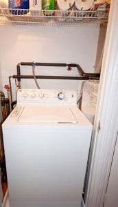 einen weißen Kühlschrank in einer Küche mit Regal in der Unterkunft Heritage Row House in Downtown Halifax in Halifax