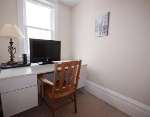 a desk with a computer monitor and a chair at Heritage Row House in Downtown Halifax in Halifax