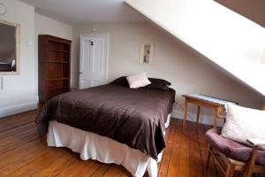 sypialnia z łóżkiem i klatką schodową w obiekcie Heritage Row House in Downtown Halifax w mieście Halifax