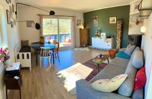 salon z kanapą i stołem w obiekcie Cosy house with sunny terrace, garden and fjord view w Bergen