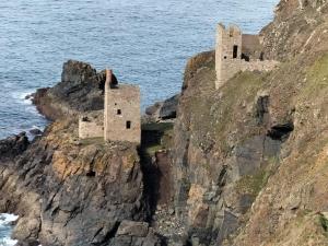 a castle on a cliff next to the ocean at Syds Corner bell tent in St. Just