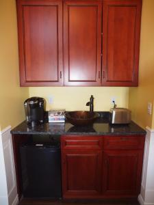 a kitchen with wooden cabinets and a sink at Bear Creek Falls Lodge on 67 acres Creek & Waterfalls in Millville