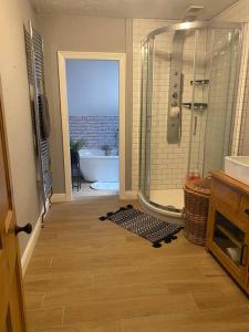 a bathroom with a shower and a bath tub at Homely 2-bed Terrace with Log Burner in Lincolnshire