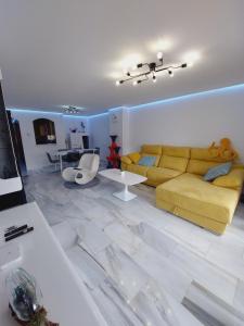 een woonkamer met een gele bank en een tafel bij L'EsCALPE BAHIA - full wifi in Calpe