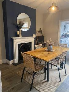 ein Esszimmer mit einem Tisch, Stühlen und einem Spiegel in der Unterkunft Homely 2-bed Terrace with Log Burner in Lincolnshire
