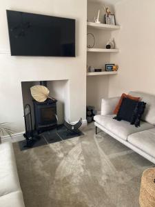 a living room with a white couch and a fireplace at Homely 2-bed Terrace with Log Burner in Lincolnshire