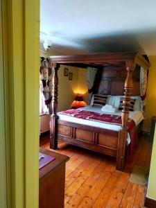 um quarto com uma grande cama de madeira num quarto em Meadow Farm Cottage em Norwich