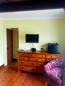 een woonkamer met een houten dressoir en een televisie. bij Meadow Farm Cottage in Norwich