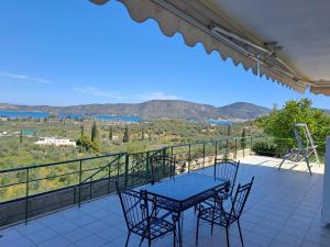 a patio with a table and chairs on a balcony at GEORGE'S VILLA in Galatas