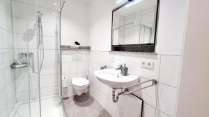 a white bathroom with a sink and a shower at Stadtgarten-Studios - im Zentrum mit Parkplatz in Weingarten