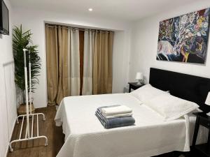 Un dormitorio con una cama blanca con toallas. en Casa Tania en Ligonde
