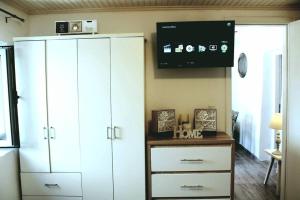 a living room with a white cabinet and a tv at Sunrise cottage in Gaios