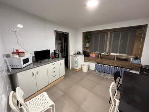 a kitchen with white cabinets and a microwave at Casa Tania in Ligonde