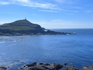 an island in the ocean with a lighthouse on it at Gwens Garden bell tent in St. Just