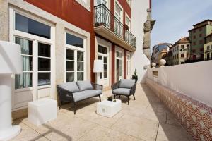 - une terrasse avec 2 chaises et des tables dans un bâtiment dans l'établissement BOUTIQUE Rentals- P*O*R*T*O Ribeira, à Porto