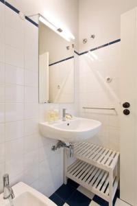 La salle de bains blanche est pourvue d'un lavabo et d'un miroir. dans l'établissement BOUTIQUE Rentals- P*O*R*T*O Ribeira, à Porto