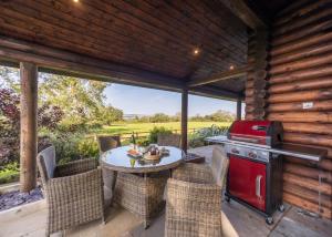 a screened in porch with a table and a grill at Sun Hill Lodges in Constable Burton