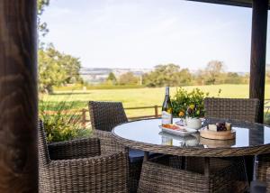 a table with a bottle of wine and a plate of food at Sun Hill Lodges in Constable Burton