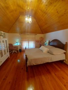ポンタ・ド・ソルにあるVivenda Por do Solの木製の天井が特徴のベッドルーム1室(大型ベッド1台付)