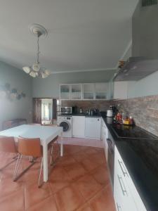 a kitchen with a white table and a counter top at Vivenda Por do Sol in Ponta do Sol