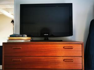a television sitting on top of a wooden dresser at Yogi Wellness Guesthouse in Klagstorp
