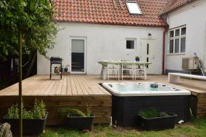 bañera de hidromasaje en una terraza de madera en Yogi Wellness Guesthouse, en Klagstorp