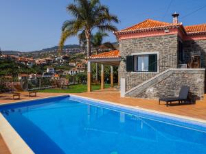 a villa with a swimming pool and a house at Vivenda Por do Sol in Ponta do Sol