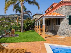 a villa with a swimming pool and a house at Vivenda Por do Sol in Ponta do Sol