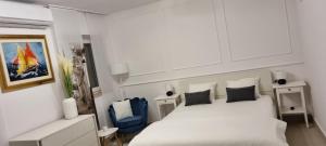1 dormitorio con 1 cama blanca y 1 silla azul en Modern apartment in the heart of Njivice, en Njivice