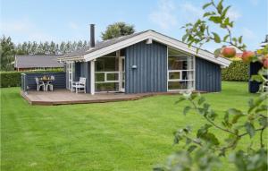 ÅrøsundにあるStunning Home In Haderslev With Kitchenの青いコテージ(デッキ、芝生の上のテーブル付)