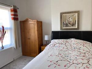 1 dormitorio con cama con edredón y ventana en Crispin House en Hunstanton