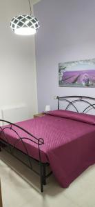 een bed met een paars dekbed in een kamer bij b&b Telesilla in Telese