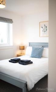 a bedroom with a bed with two towels on it at The Lookout, Modern Home from Home, Sleeps 5, with private parking & outside terrace in St Ives