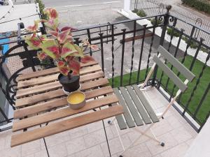 eine Holzbank mit einer Topfpflanze auf dem Balkon in der Unterkunft Vinessa Home in Peschiera del Garda
