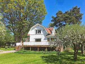 uma casa branca com um alpendre e árvores em Holiday home ÅKERSBERGA V em Akersberga
