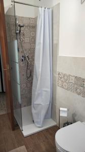 y baño con ducha, aseo y cortina de ducha. en APPARTAMENTO LA SPIAGGETTA, en Foligno