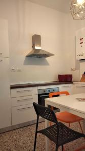 a kitchen with a stove and a table with chairs at APPARTAMENTO LA SPIAGGETTA in Foligno