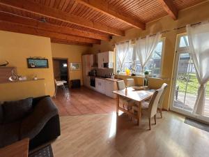 a living room with a dining table and a kitchen at Gemütlicher Bungalow am Meer in Pepelow in Pepelow