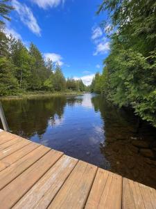 a view of a river from a wooden dock at Bungalow sur le lac in Chertsey