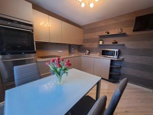 a kitchen with a table with a vase of flowers on it at Good J&I apartment in Balvi