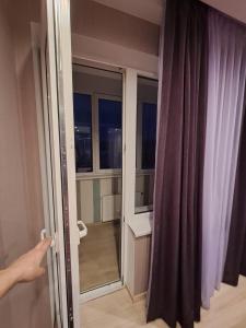 una persona che apre una porta ad una camera con finestra di Good J&I apartment a Balvi