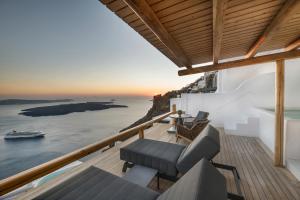 a house on the cliff with a view of the ocean at Aqua Luxury Suites Santorini in Imerovigli