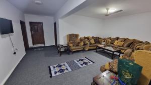 a living room with couches and a flat screen tv at Stay Classy Apartments in Wadi Musa