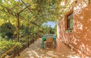 Un patio con una mesa verde y sillas bajo un cenador. en Stunning Home In Menfi Ag With Kitchen, en Portopalo di Capo Passero 23 fotos más